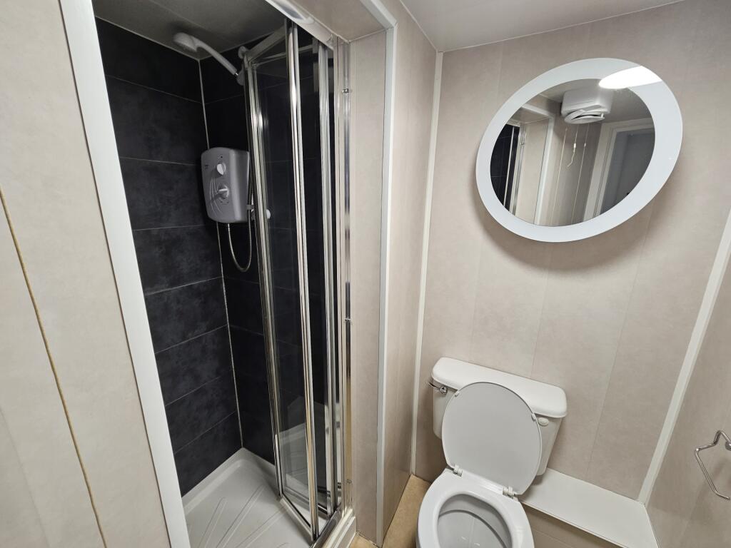 A modern and compact bathroom featuring a showe...