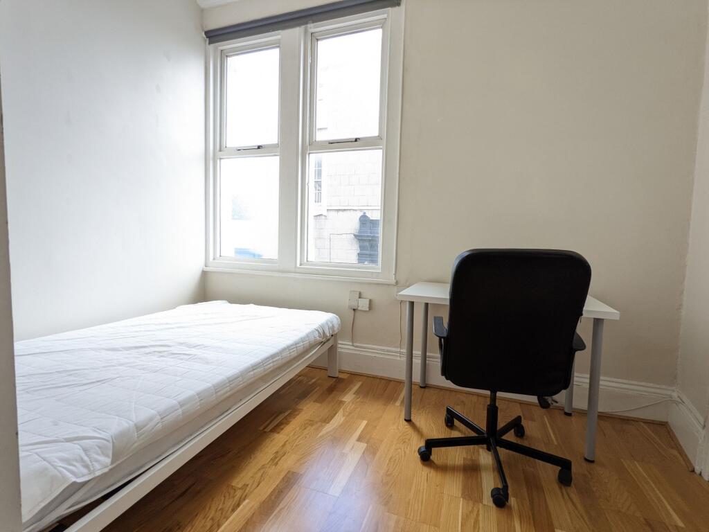 Bright, simply furnished single bedroom with a ...