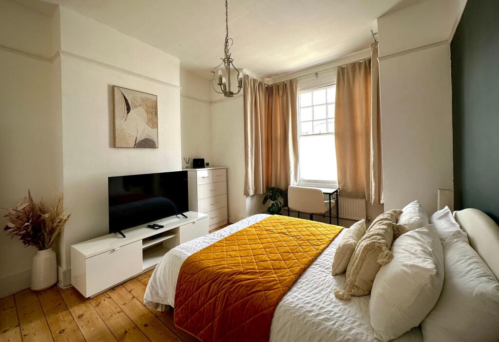 A bright and inviting master bedroom featuring ...