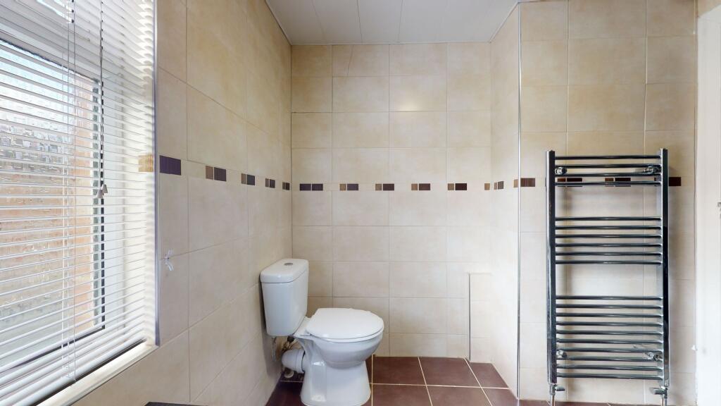 Bright and clean bathroom with a large window, ...