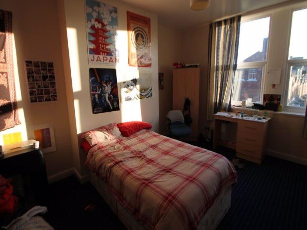 A cozy single bedroom featuring a comfortable b...