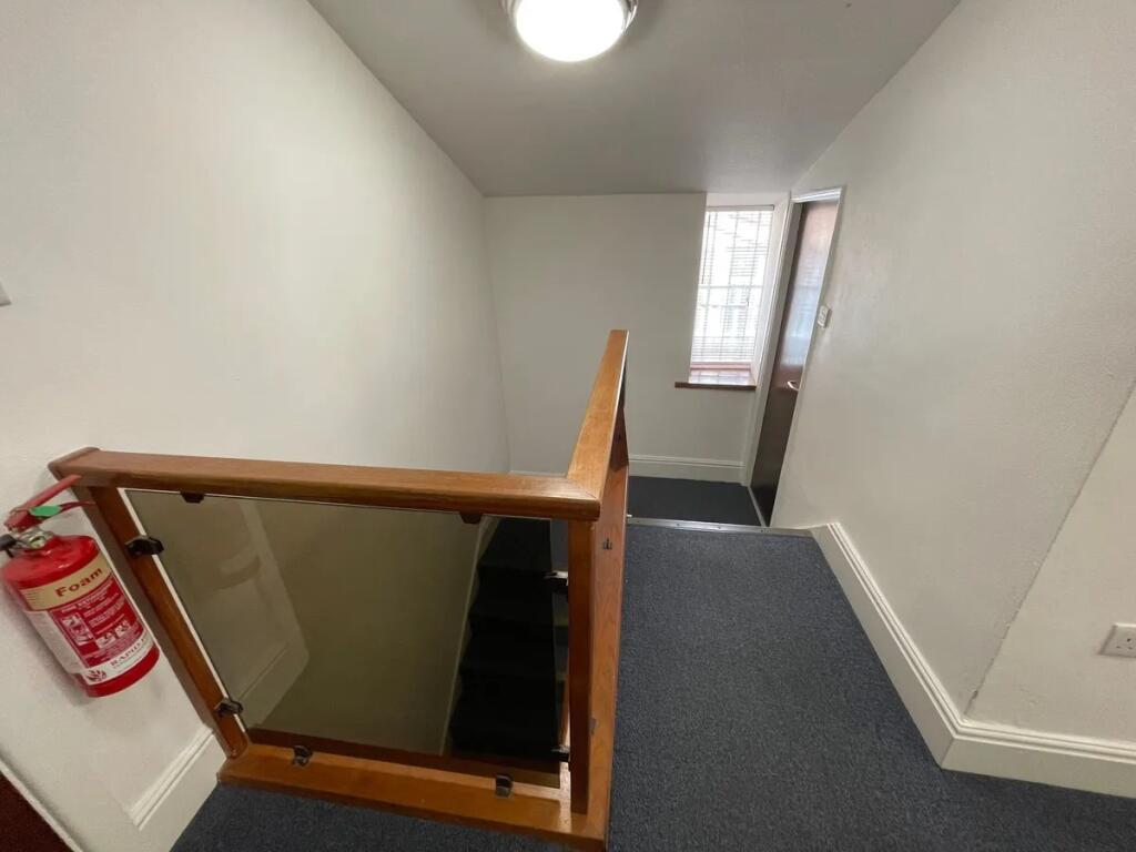 Well-maintained staircase area featuring a secu...