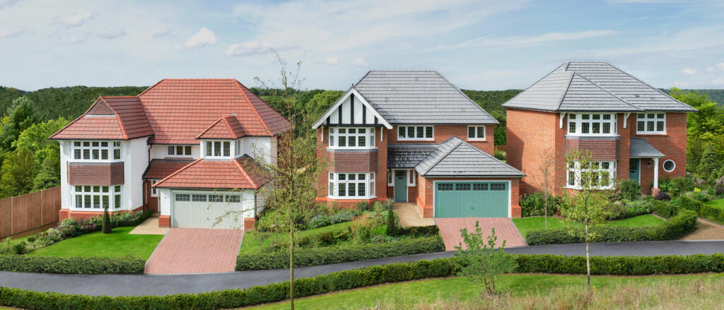 Three modern detached houses with brick exteriors and grey tiled roofs, surrounded by lush greenery