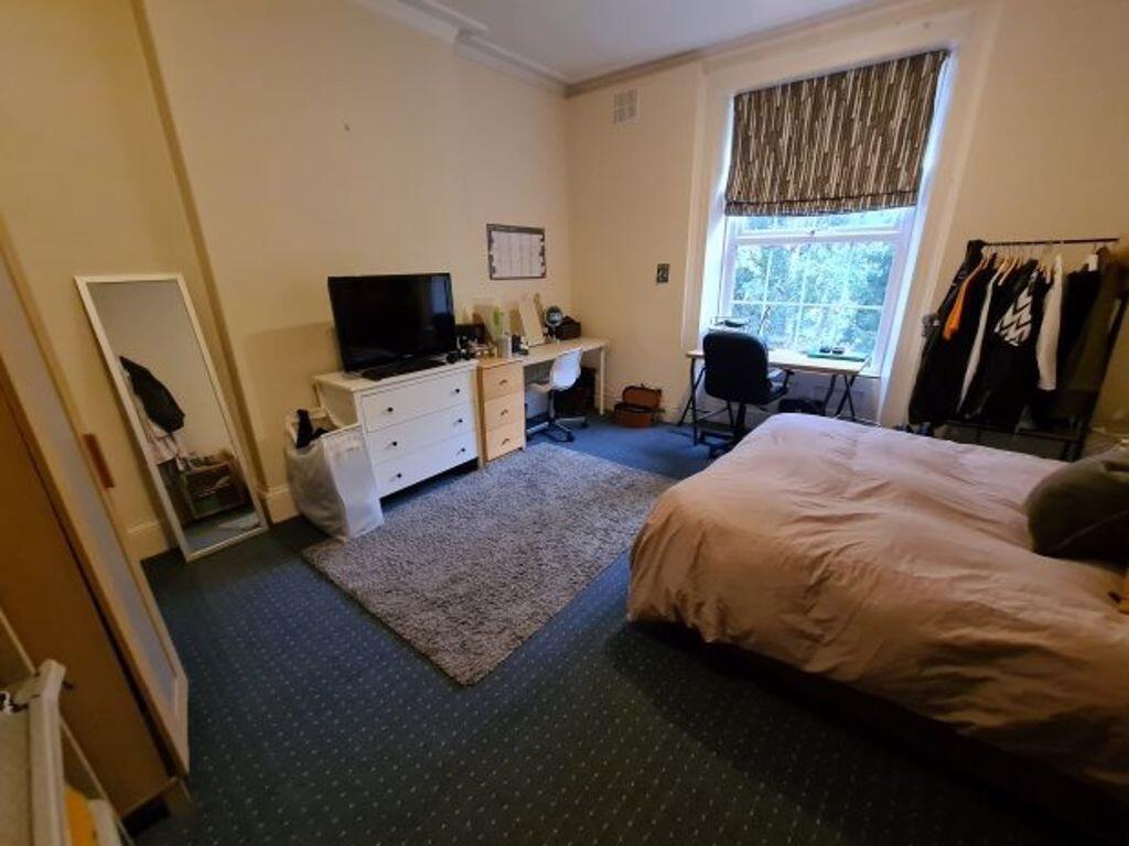 A bright and cozy bedroom featuring a comfortab...