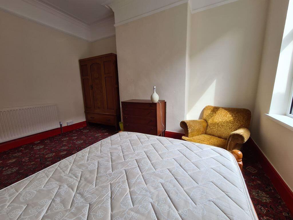 A bright double bedroom with a large window all...