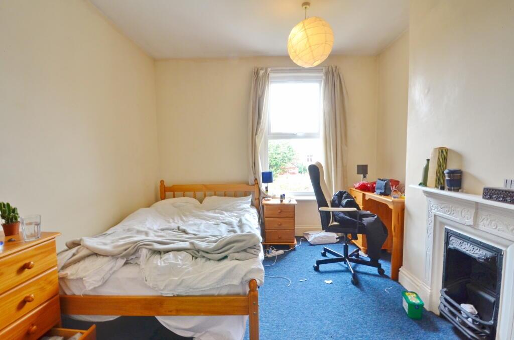 A cozy single bedroom featuring a comfortable b...