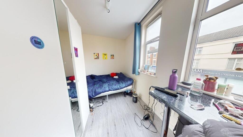Bright and neatly arranged single bedroom featu...