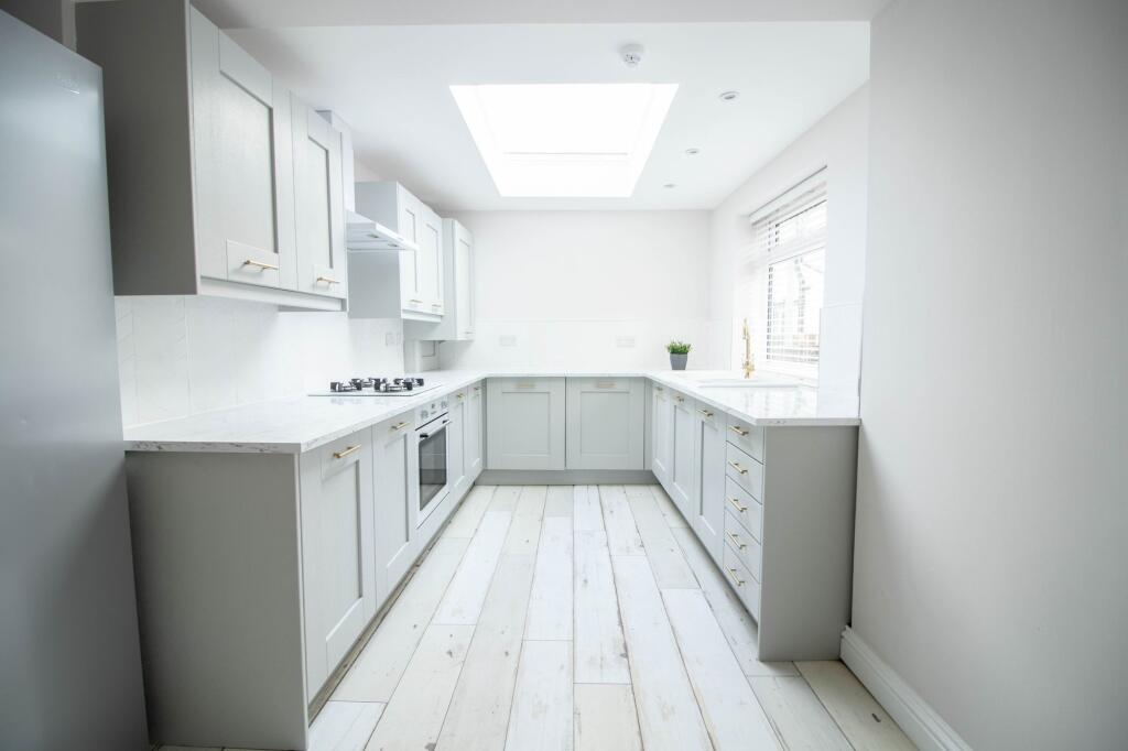 Bright and modern kitchen featuring sleek white...