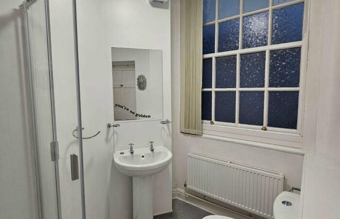 Bright and clean bathroom featuring a pedestal ...