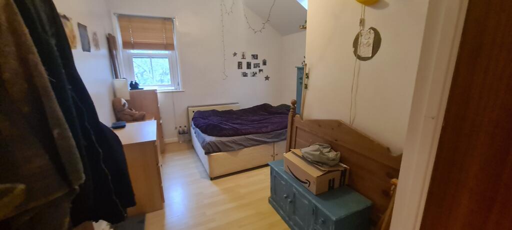 A cozy bedroom with a single bed, a small windo...