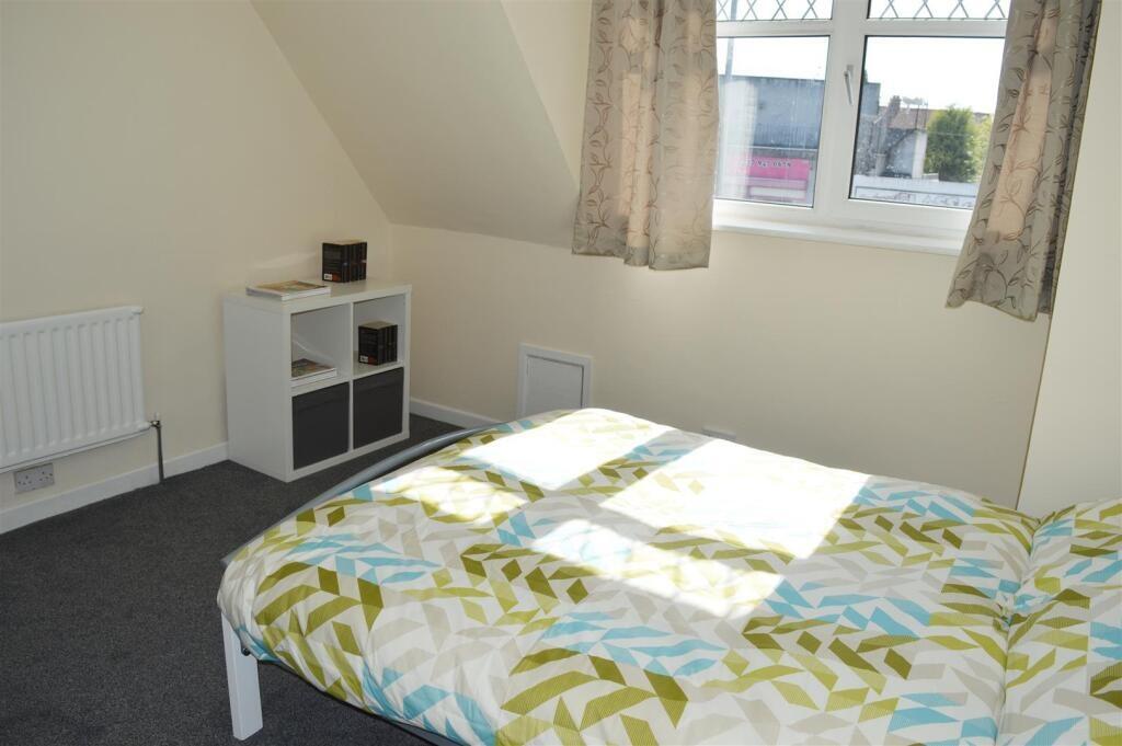 This cozy double bedroom features ample natural...