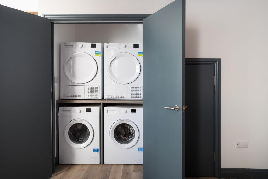 Neat built-in laundry closet with a stacked was...