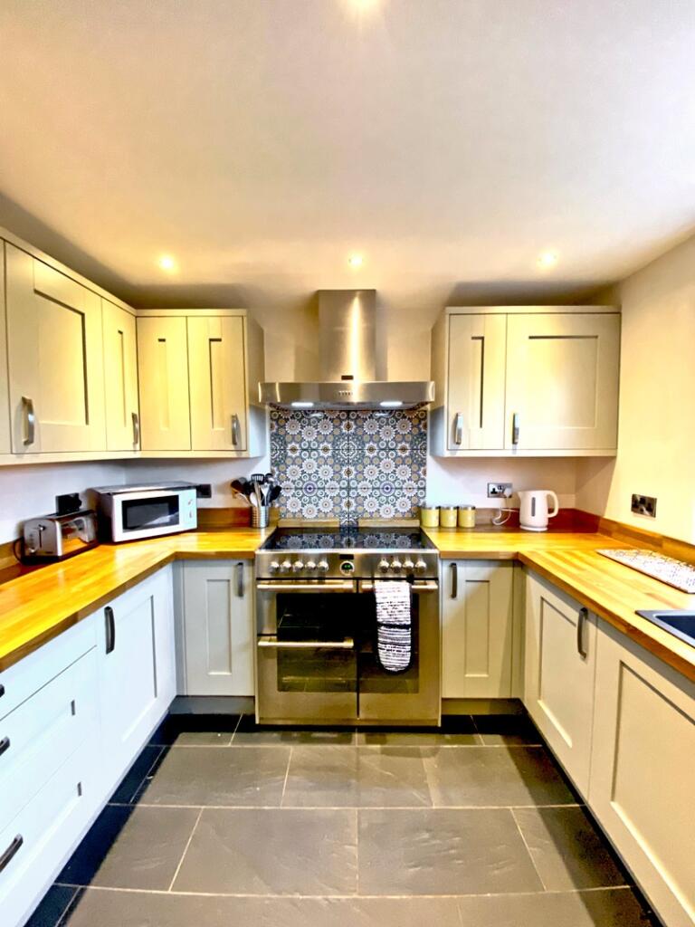 This modern kitchen features stylish cabinetry,...