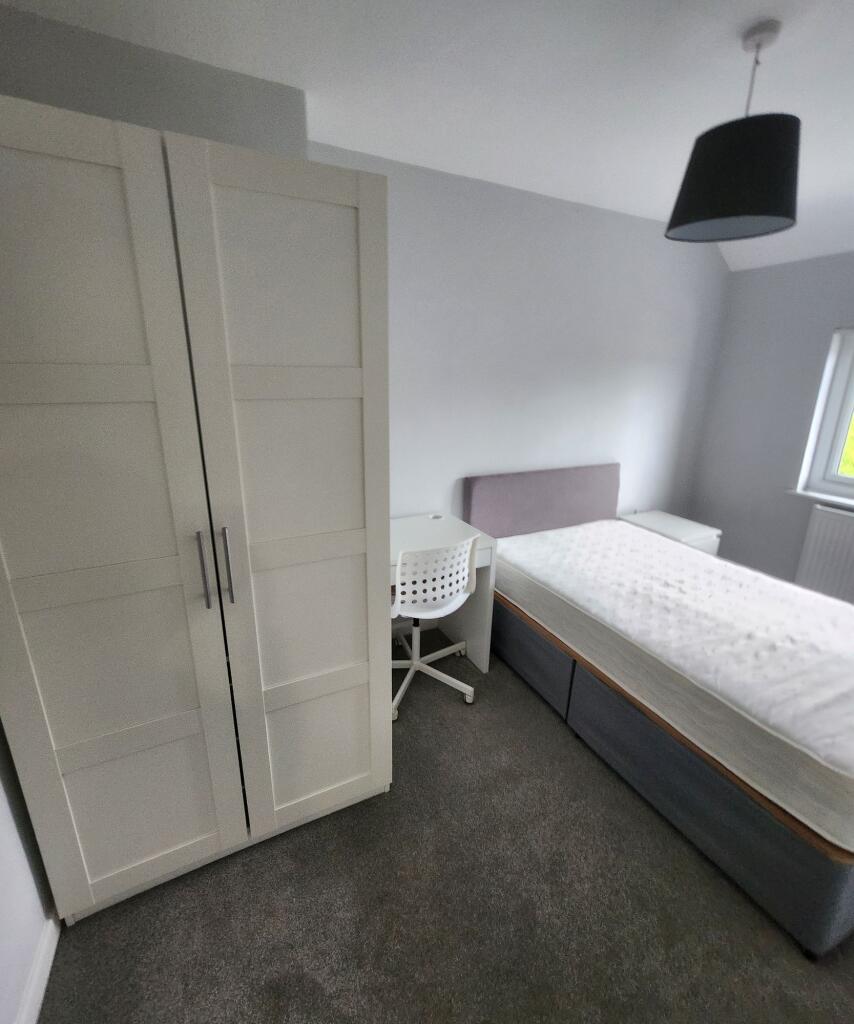 A bright, tidy bedroom featuring a comfortable ...