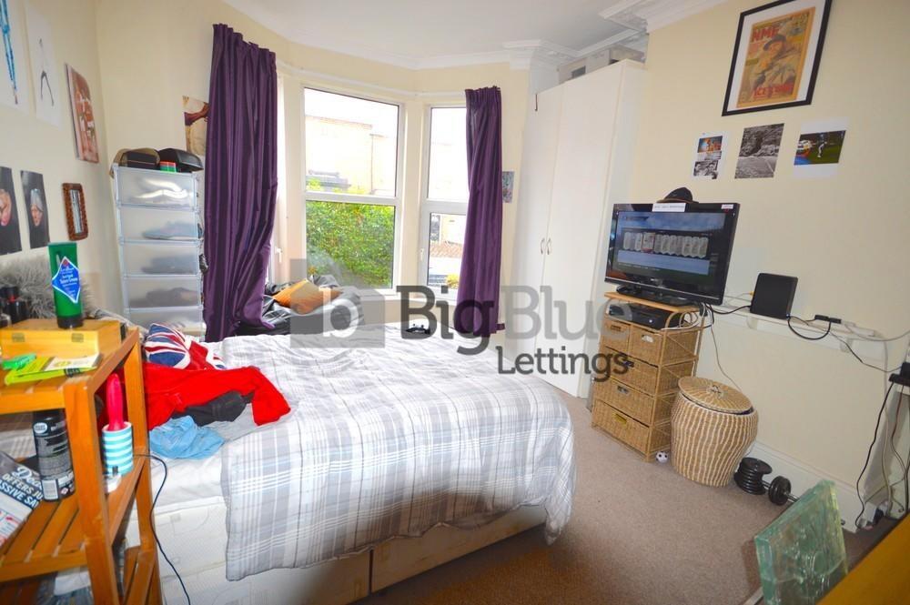 A cozy single bedroom with a comfortable bed, a...