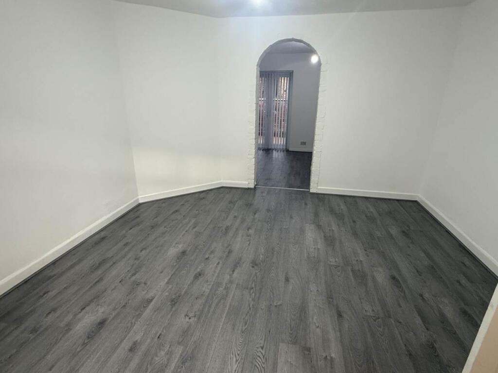 A bright, clean bedroom with modern flooring an...