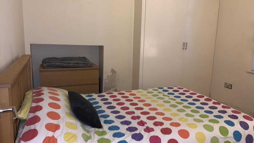 A cozy double bedroom featuring a colorful polk...