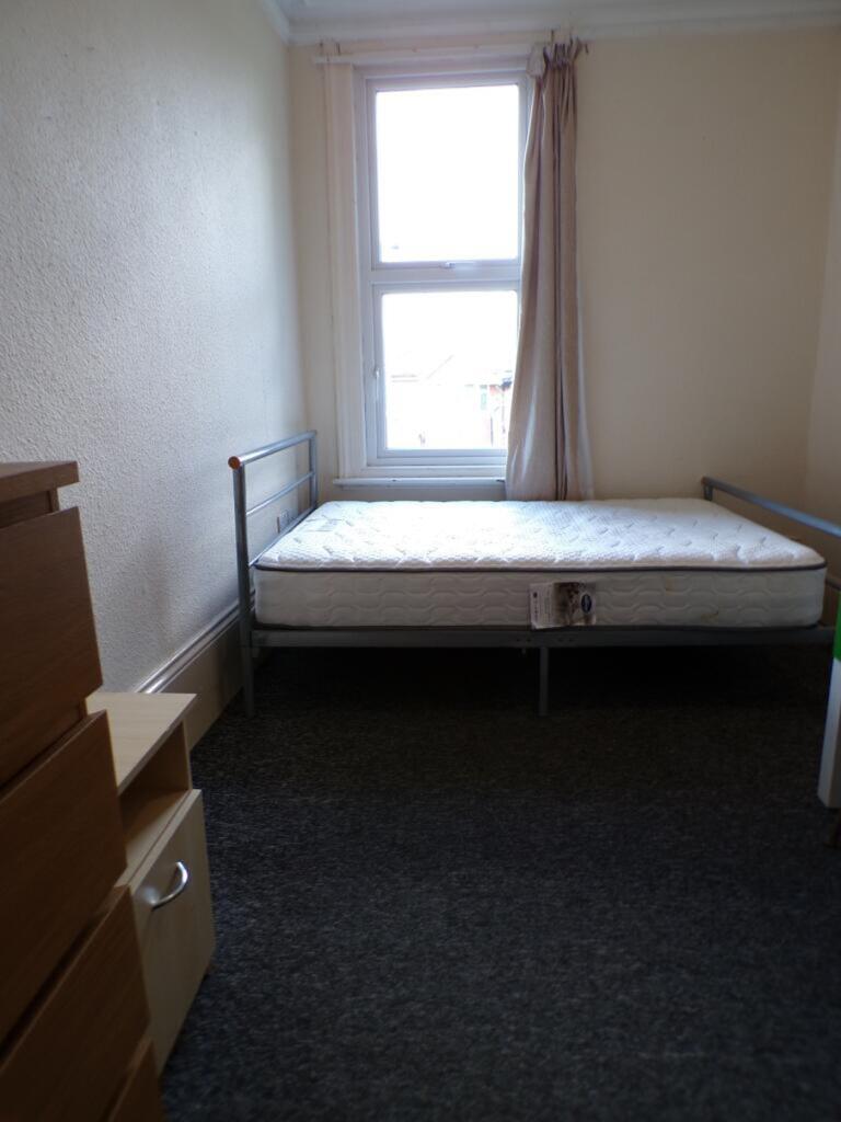 A cozy double bedroom featuring a large window ...