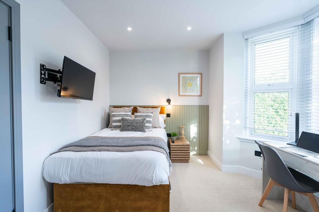 Bright and welcoming bedroom featuring a comfor...