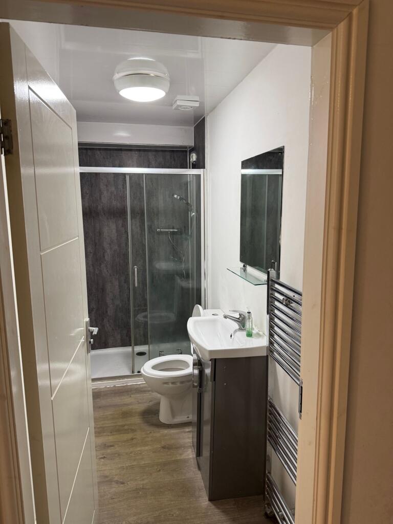 A modern bathroom featuring a glass-enclosed sh...