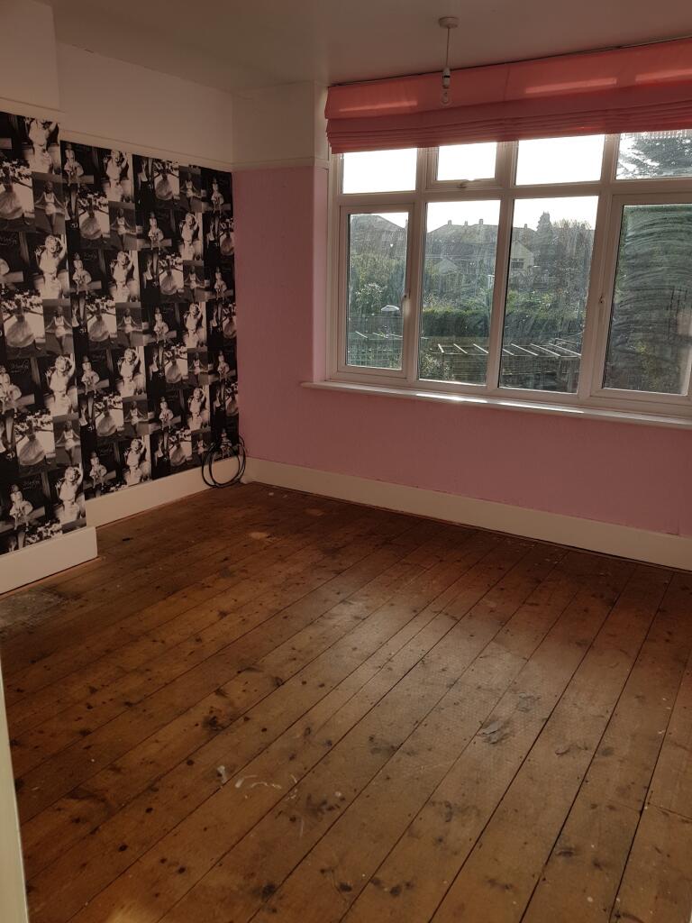 A spacious double bedroom featuring large windo...