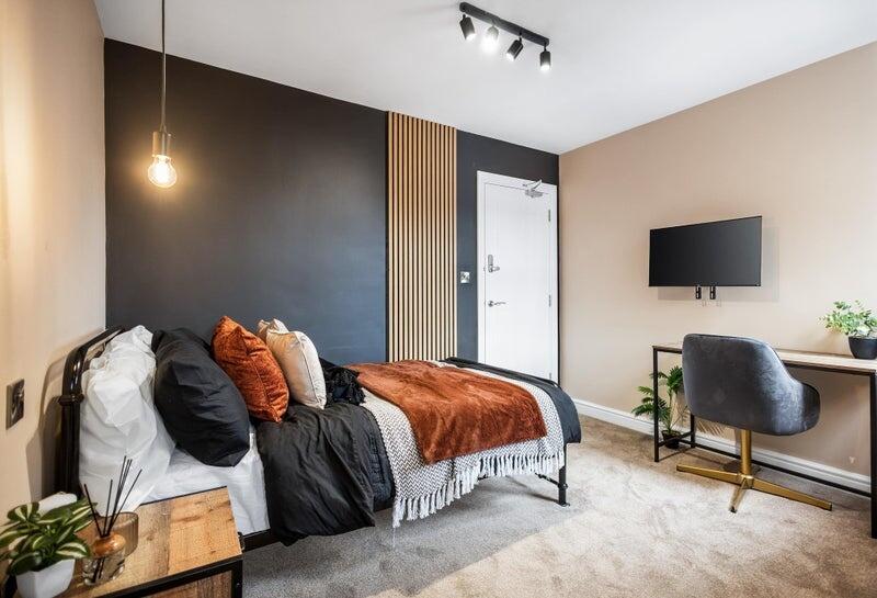 A stylish single bedroom featuring a cozy bed w...