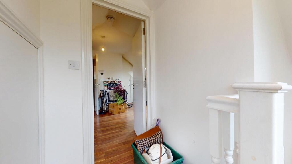 A bright hallway with white walls and a wooden ...