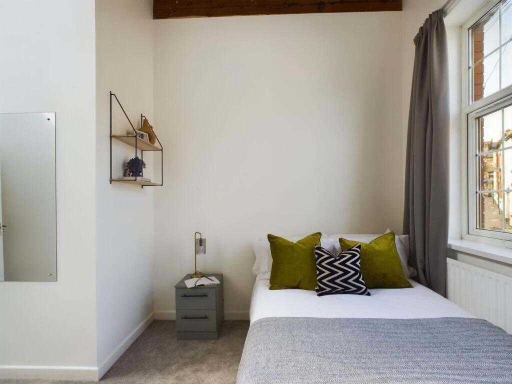 A bright and inviting double bedroom featuring ...