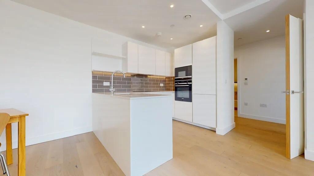 Bright and modern kitchen featuring sleek white...