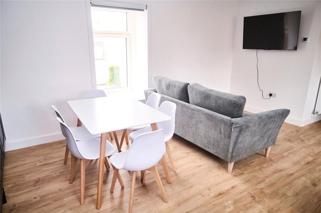 A contemporary living room featuring a cozy gre...