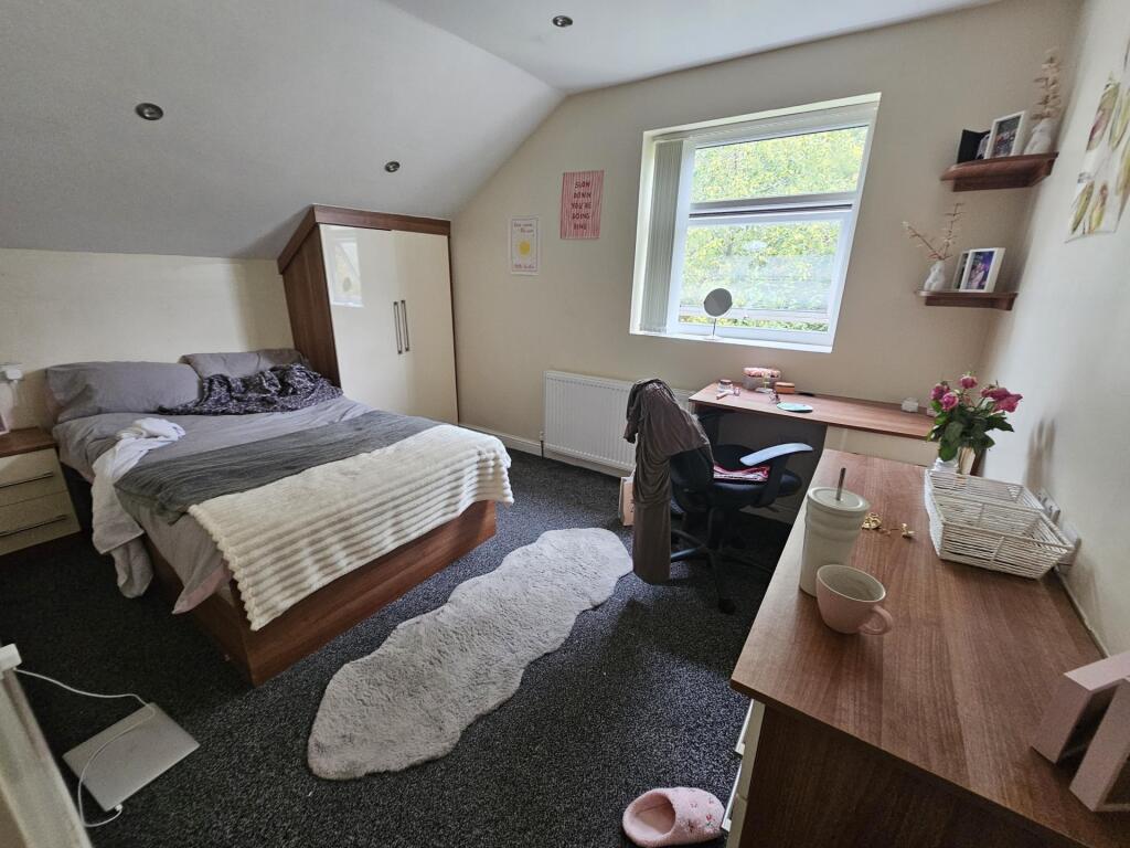 Spacious and well-lit bedroom featuring a comfo...