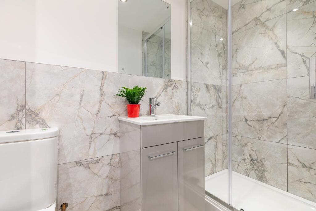 A modern bathroom featuring a large shower encl...