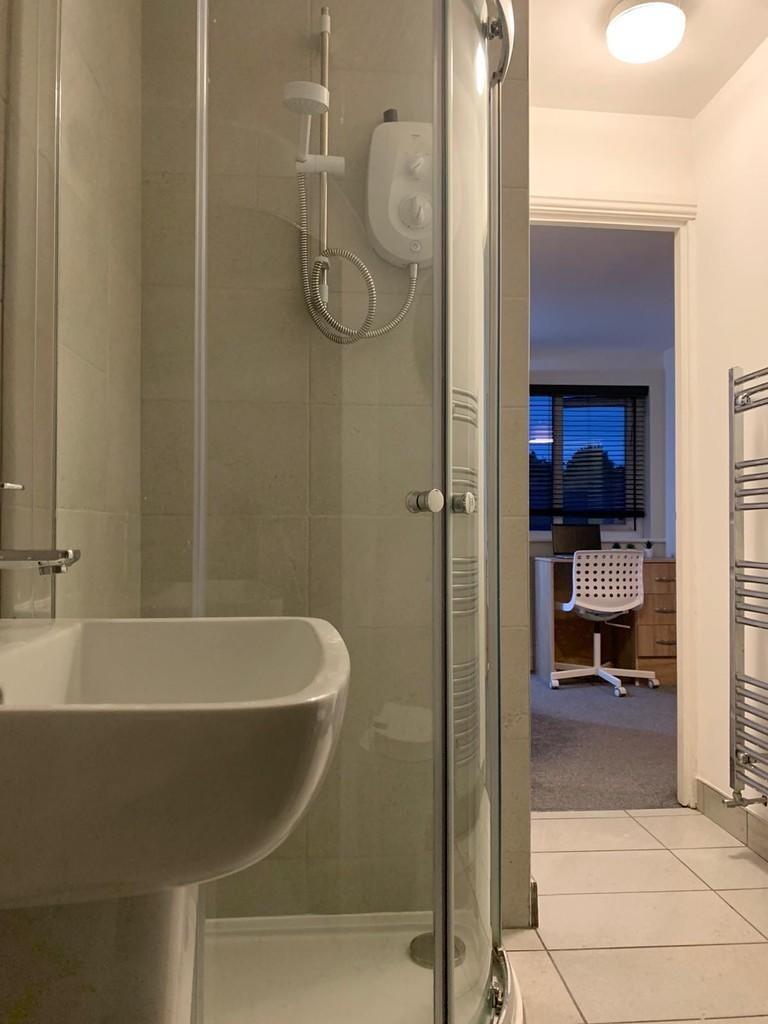 Modern bathroom featuring a clean glass-enclose...