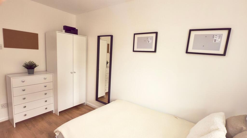Bright and tidy bedroom featuring a comfortable...