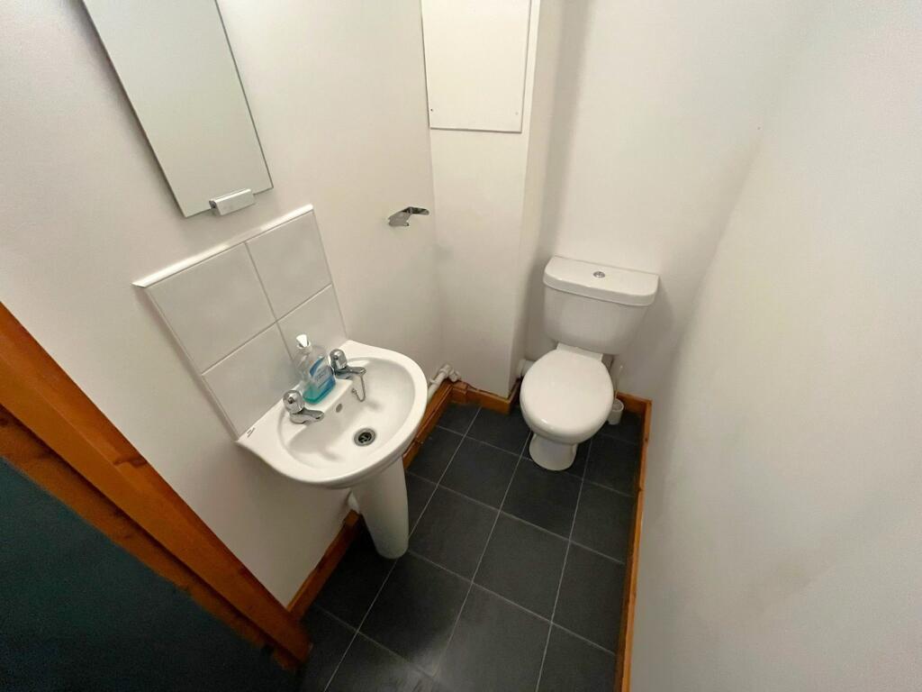 A tidy and functional single toilet with modern...