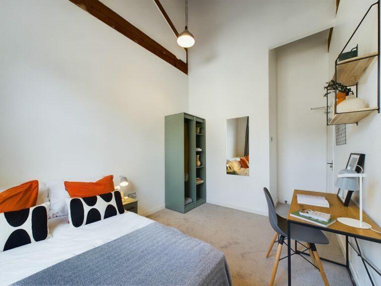 Bright, spacious bedroom featuring a comfortabl...