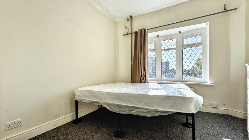 A simple and clean single bedroom featuring a l...