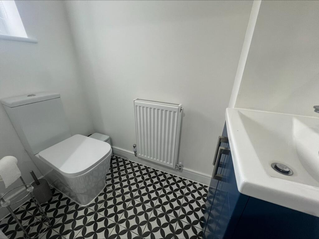 A modern and tidy single toilet room featuring ...