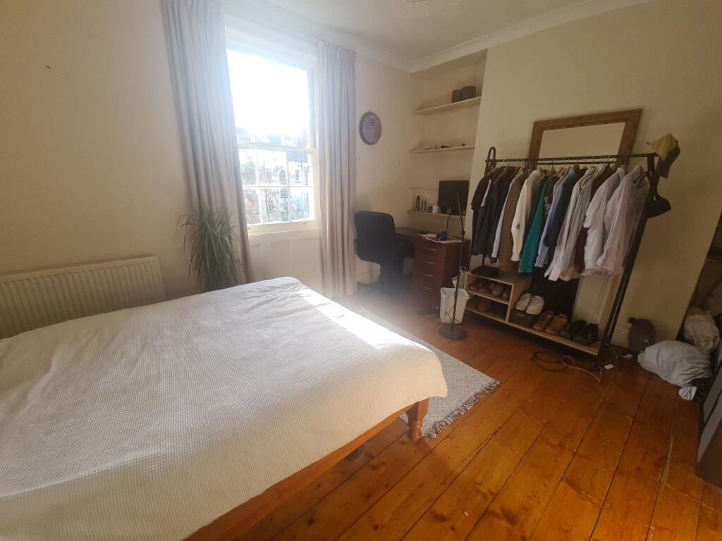 A cozy bedroom featuring a neatly made bed, gen...