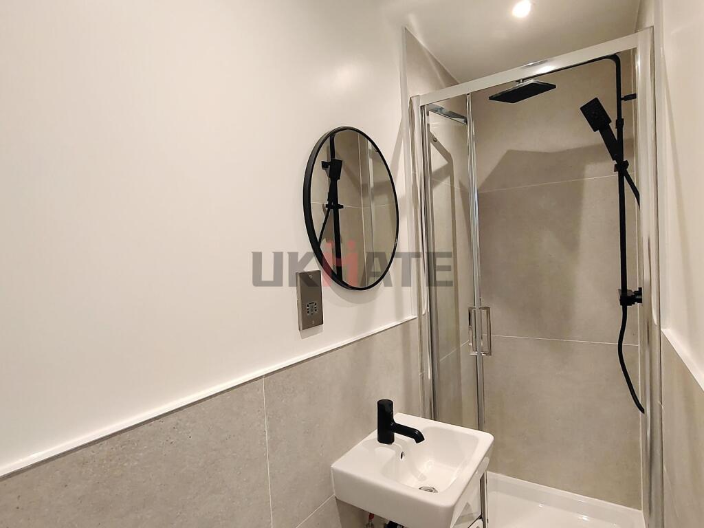 A clean, modern bathroom featuring a walk-in sh...