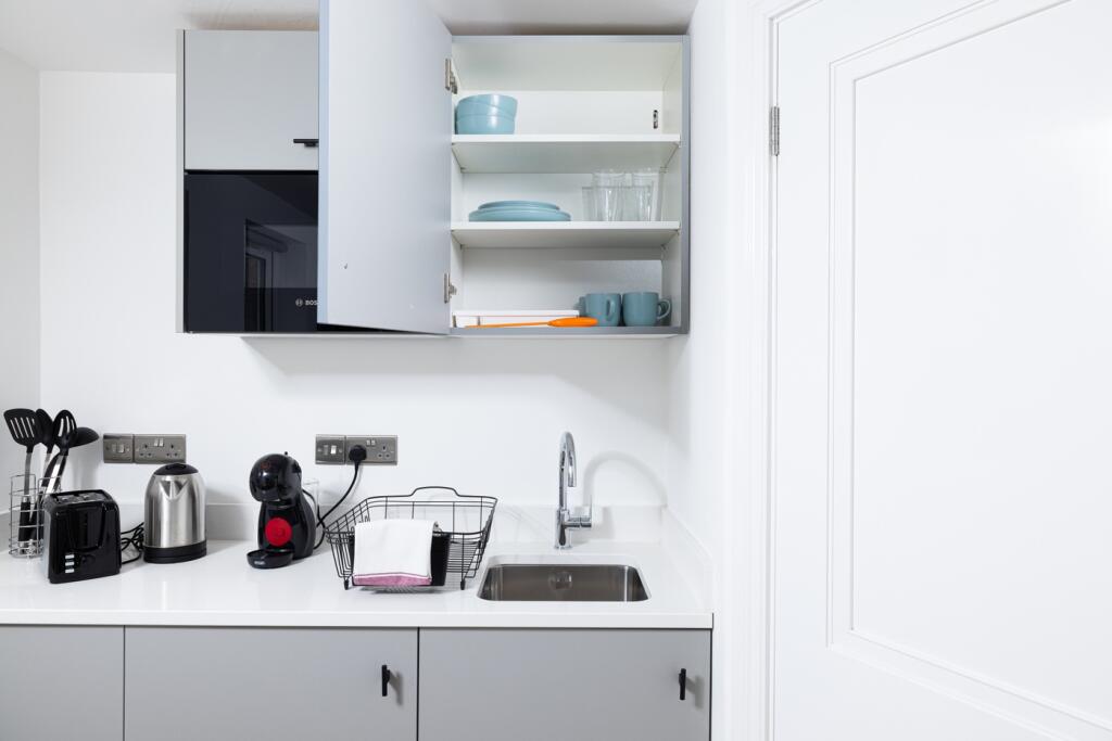 A modern kitchen featuring sleek cabinetry, amp...