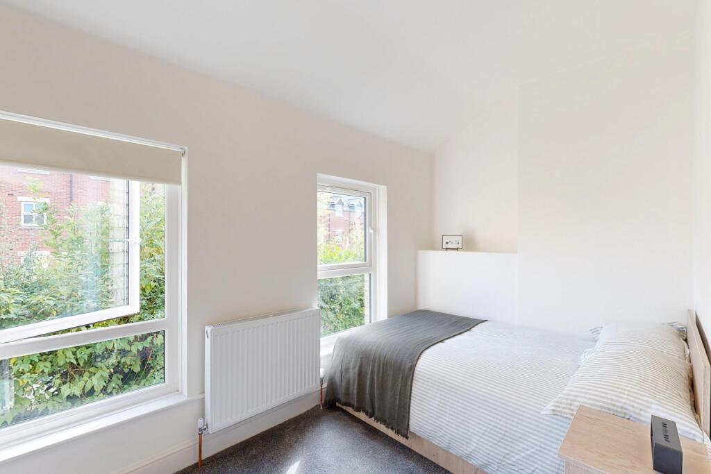 Bright and spacious master bedroom with large w...