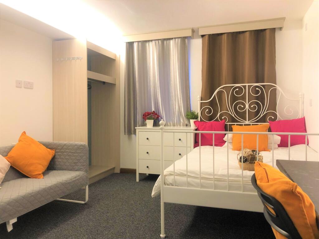 A cozy double bedroom featuring a white metal b...