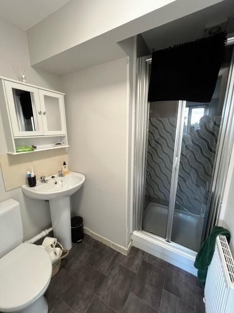 Neat, modern bathroom with a corner shower encl...