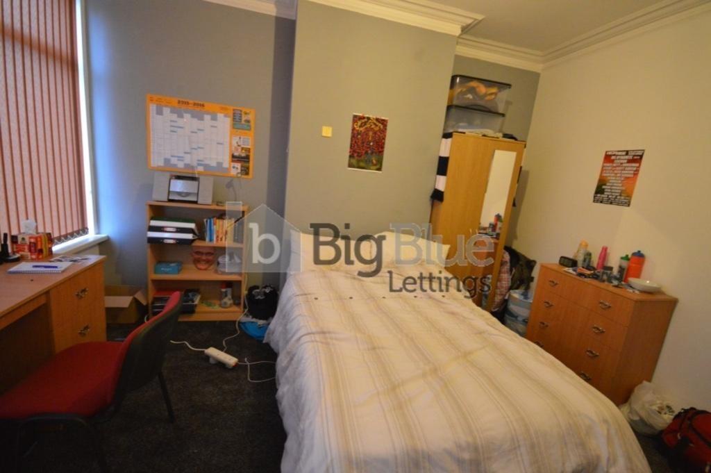 A cozy single bedroom featuring a neatly made b...