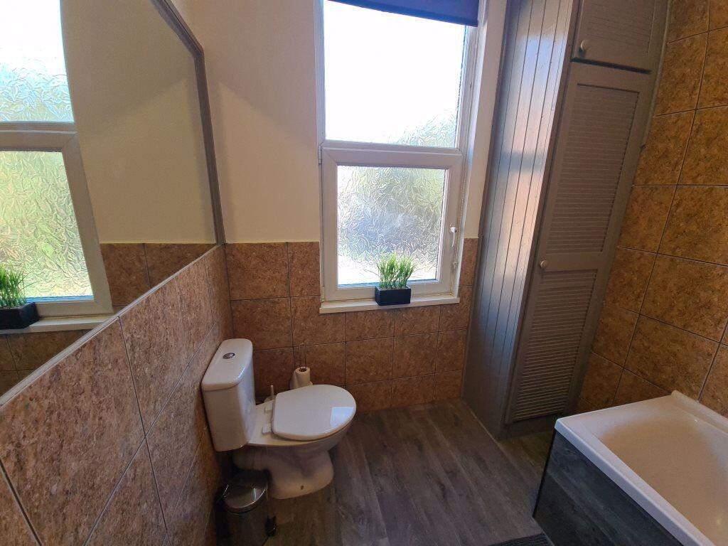Bright and clean bathroom suite featuring a ful...