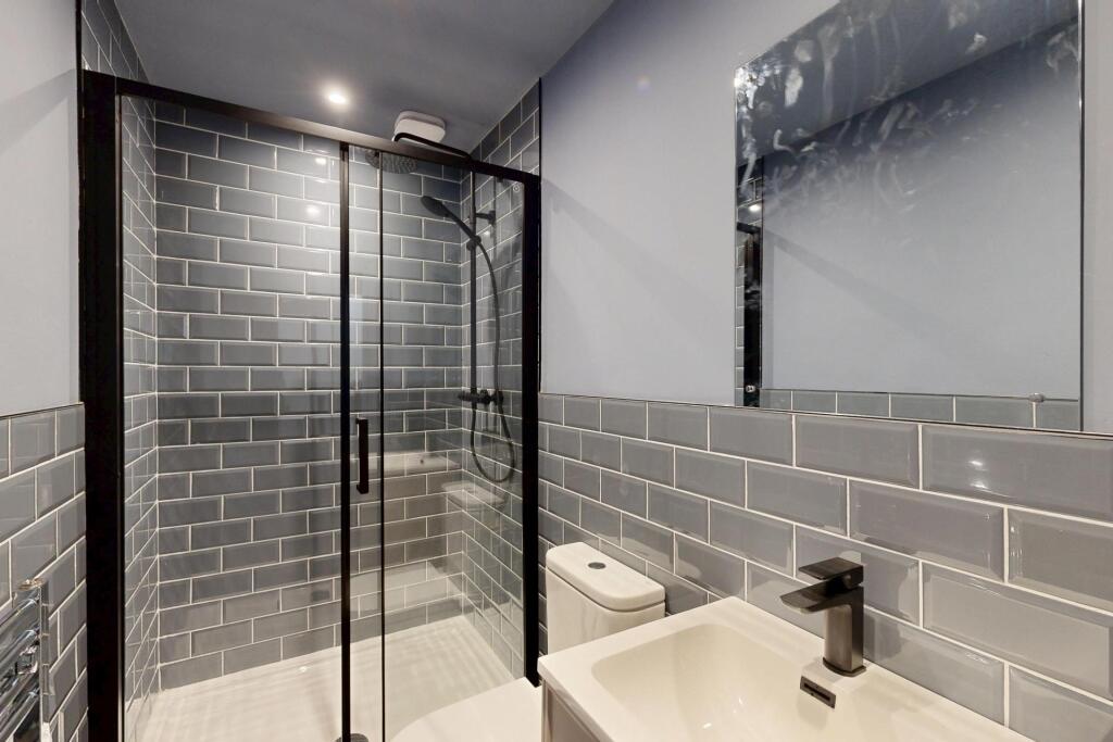 Modern bathroom featuring a sleek walk-in showe...