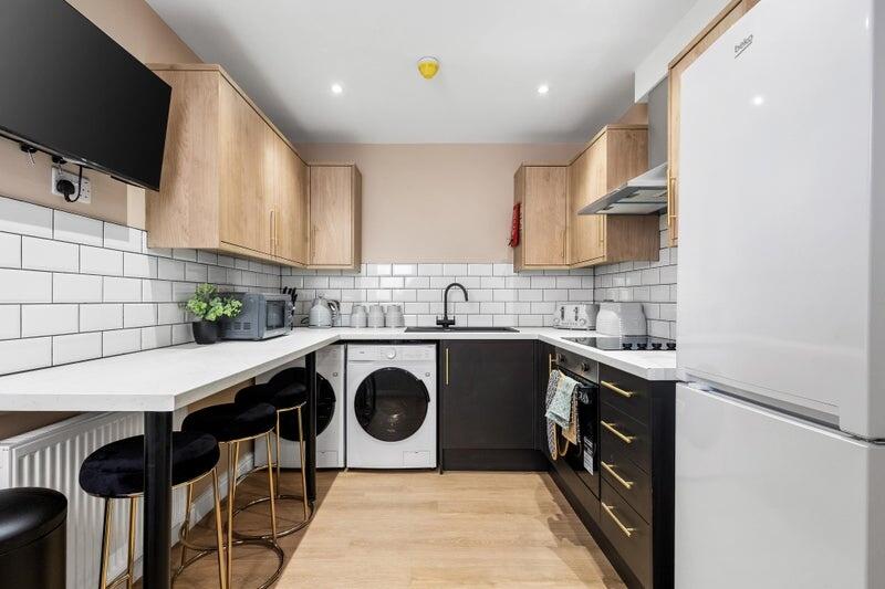 Bright and modern kitchen featuring stylish bla...