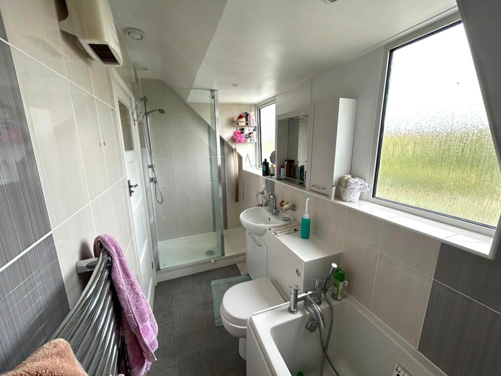 Bright modern bathroom with a large window, wal...