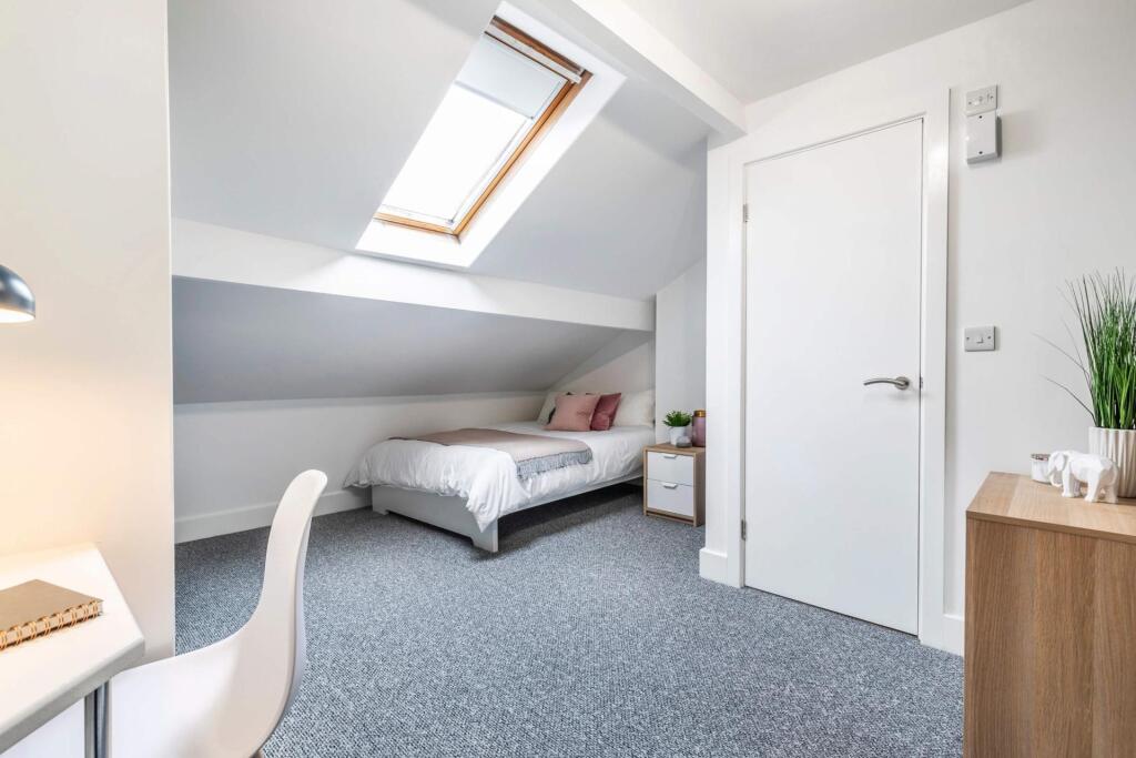 A bright and tidy single bedroom featuring a co...